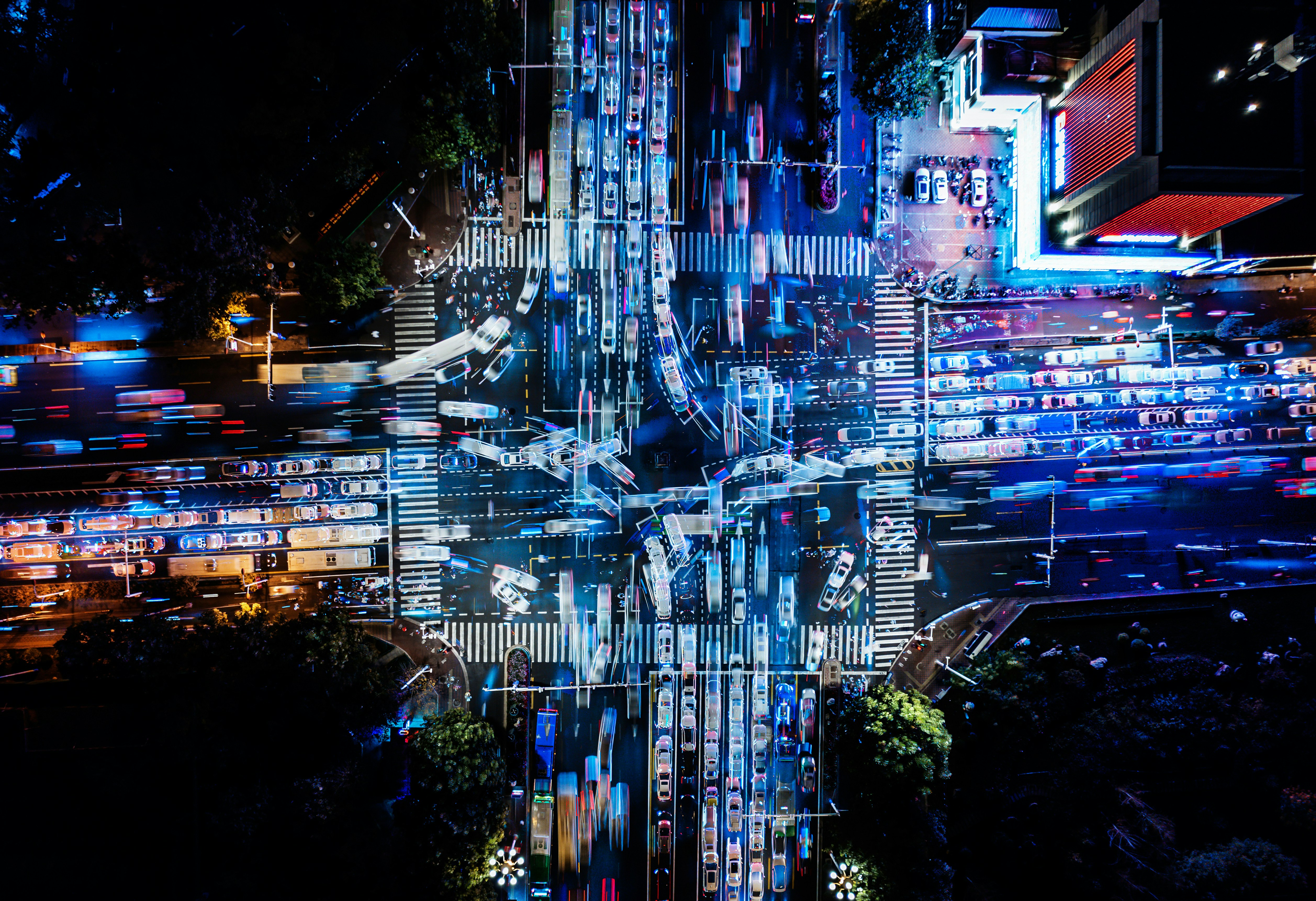 Light trails crossing a busy city intersection at night