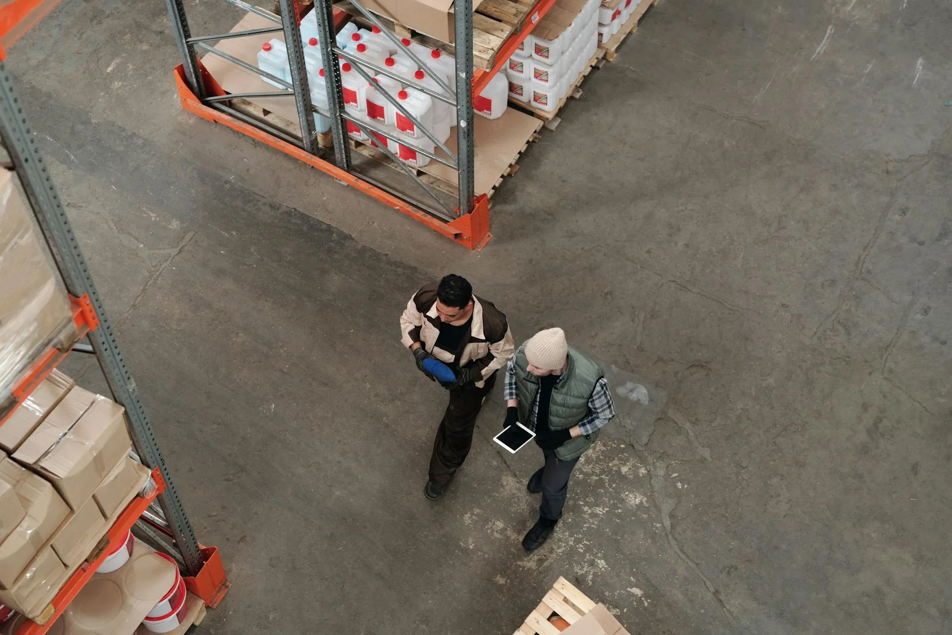 Two colleagues reviewing a tablet on the warehouse floor