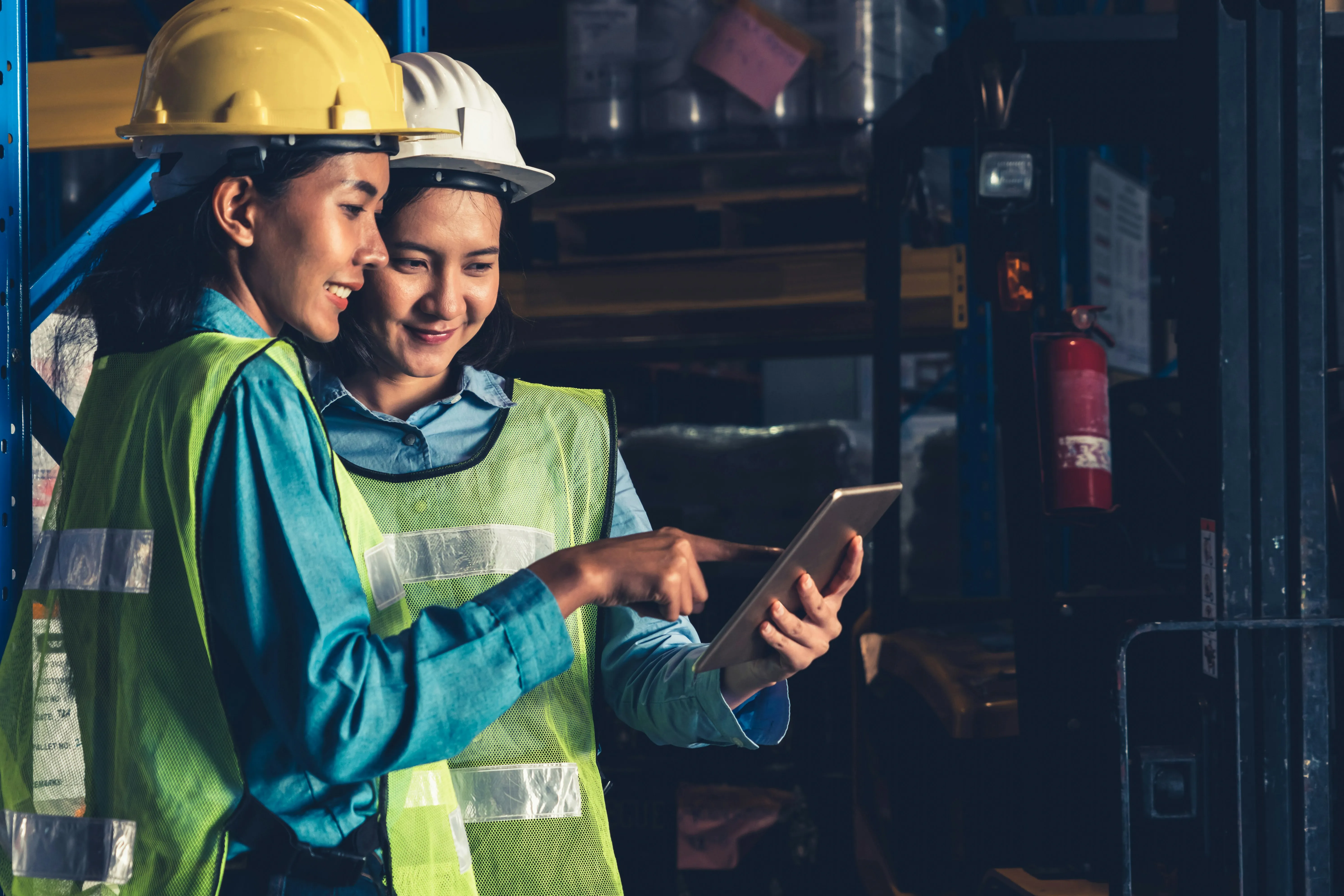 Warehouse workers collaborating on tablets, activating AI agents across supply chain systems